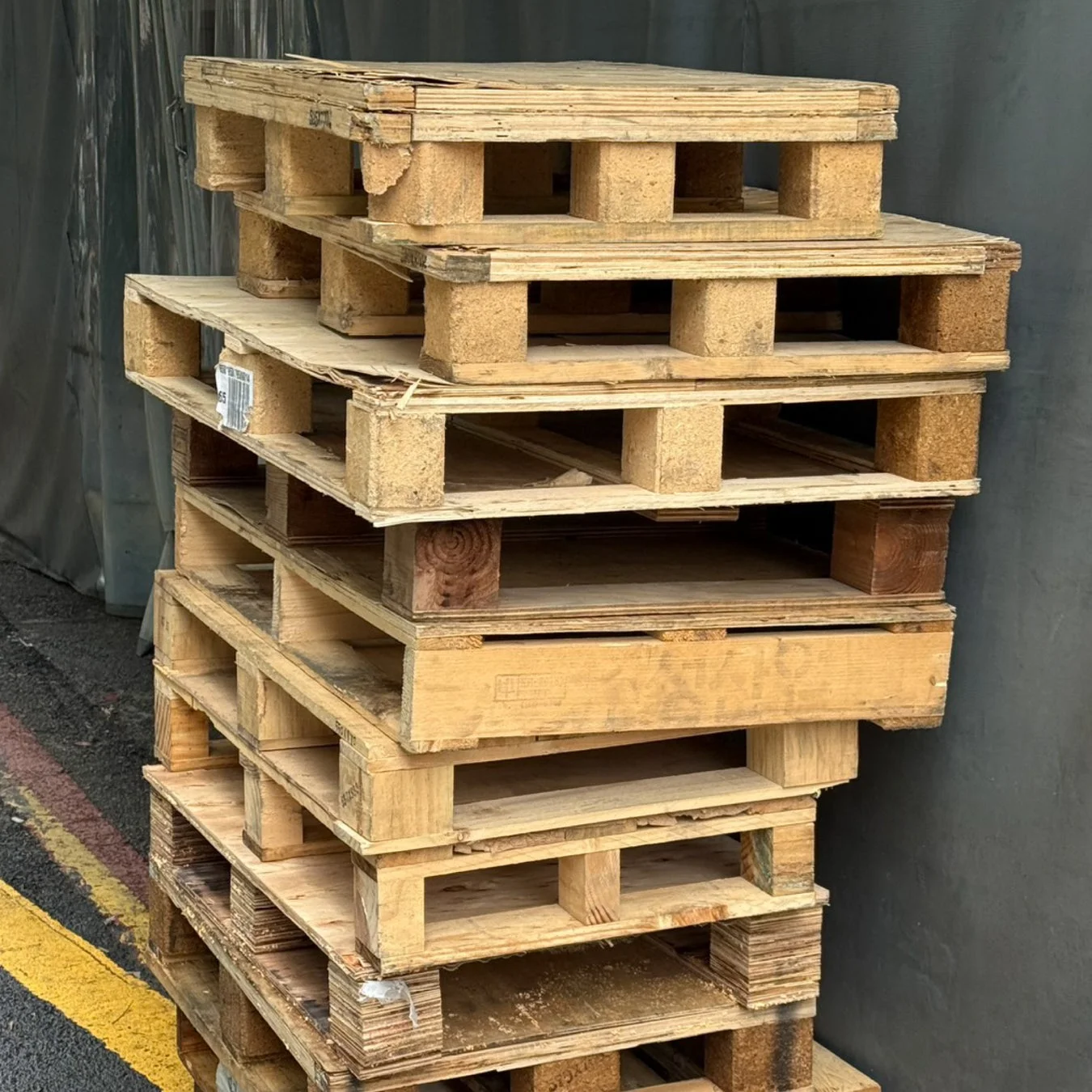 倉庫のような場所に積み重ねられた木製パレット