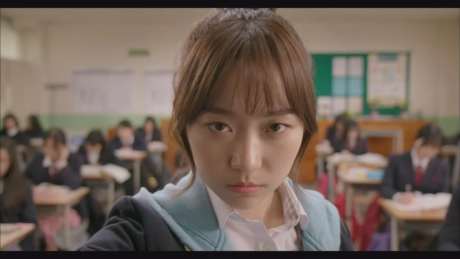 教室で真剣な表情を見せる女子学生