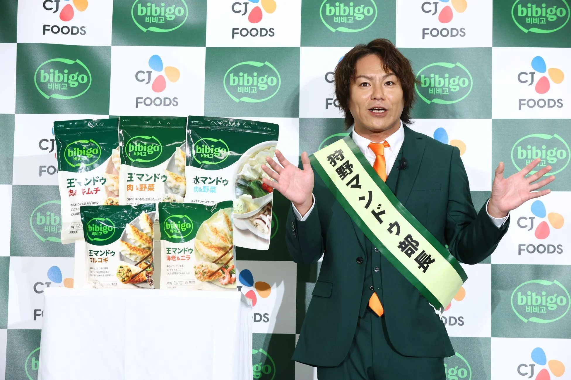 特製マンドゥ部長のサッシュを着用しアピールする狩野英孝さん