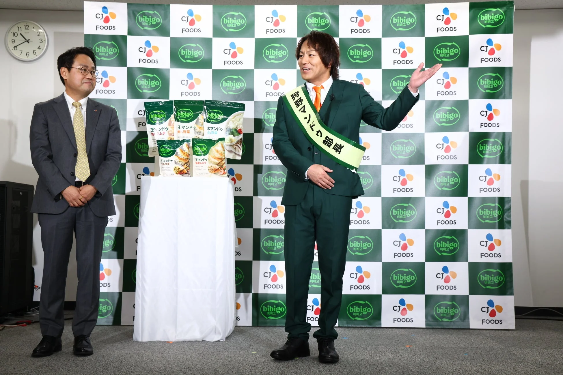 金代表取締役とマンドゥ商品を披露する狩野英孝さん