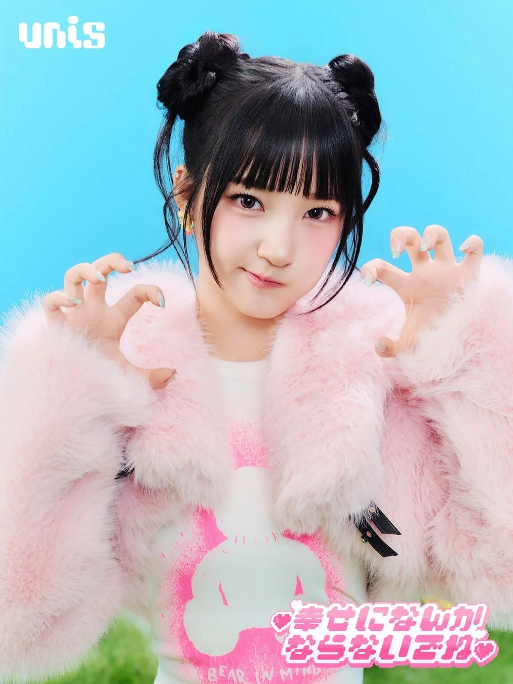 ピンクのふわふわのジャケットを着用し、お団子ヘアの女性