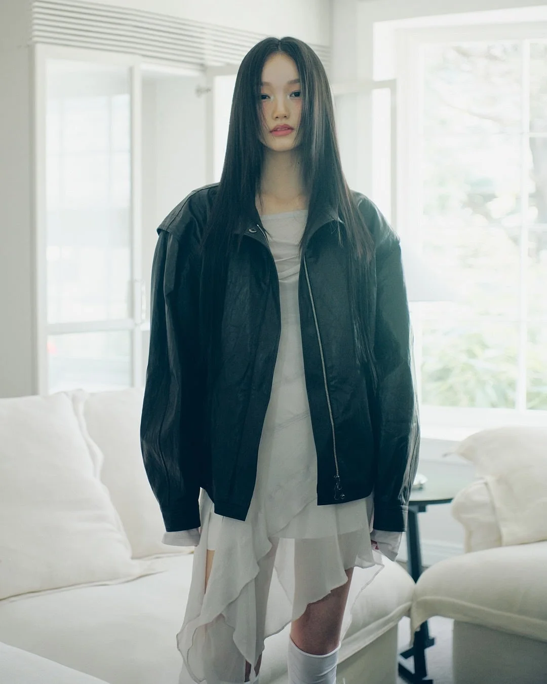 黒いジャケットと白いフリルドレスを着た女性