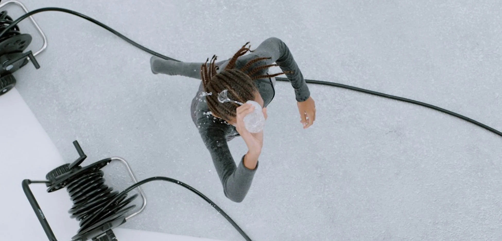 ドレッドヘアの人物が水をかけている