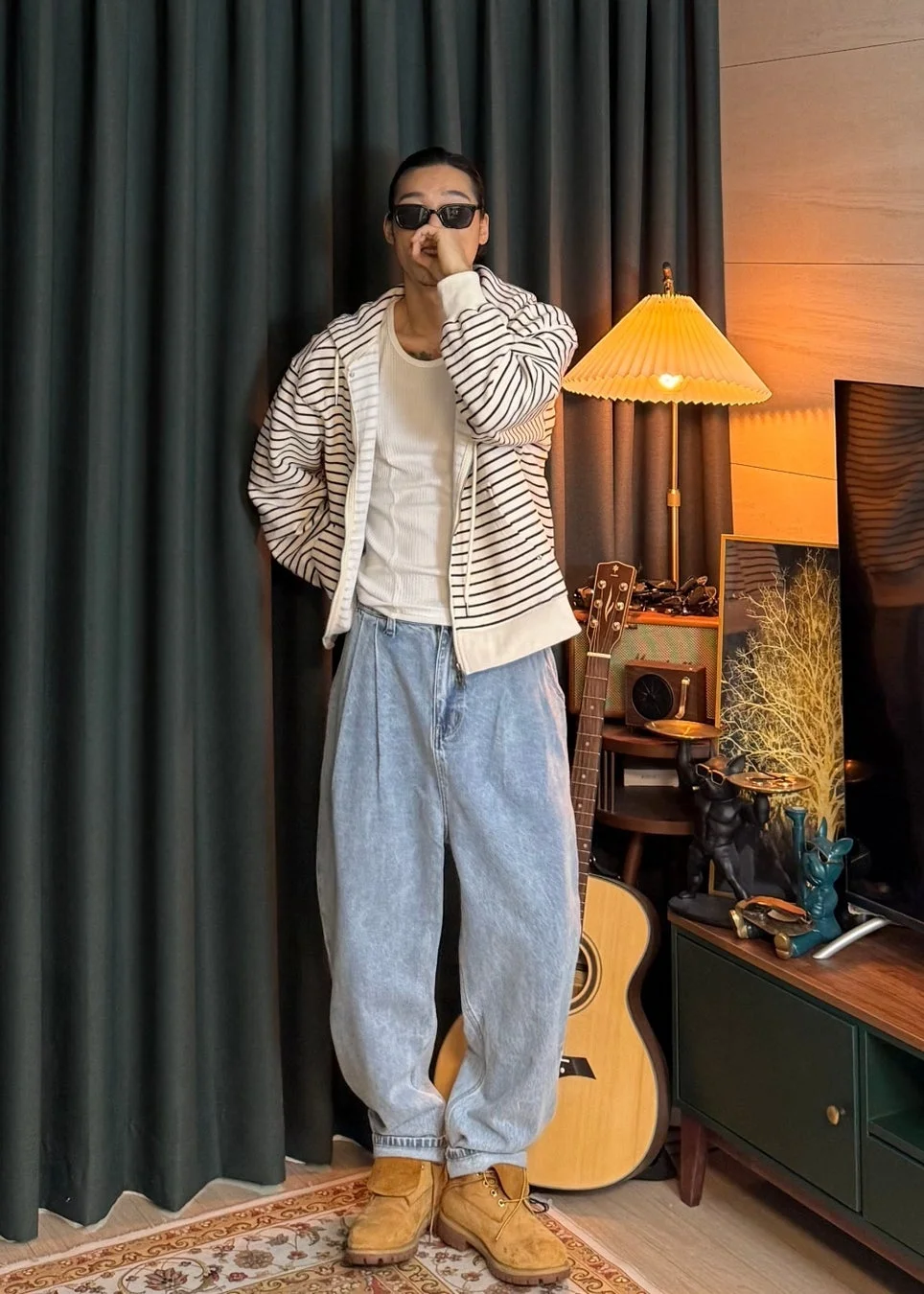 男性がストライプパーカーとデニムパンツを着用